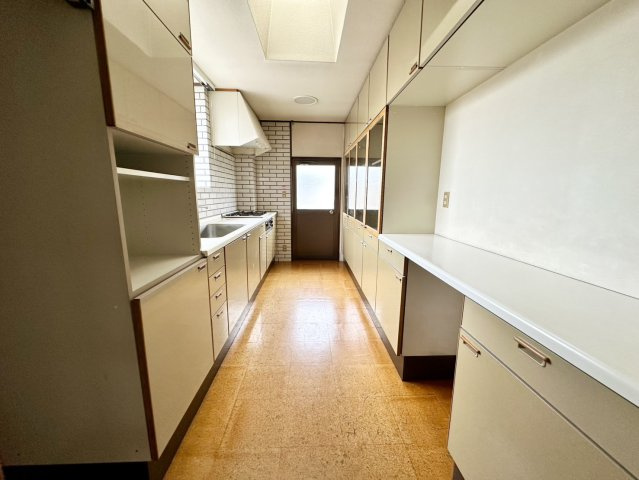 ゆとりあるキッチンスペースは、作業動線が確保されており、ご家族での調理や配膳もスムーズに行えます。収納力の高いカップボードや吊戸棚を備えているため、食器や調理器具をすっきり整理可能です。