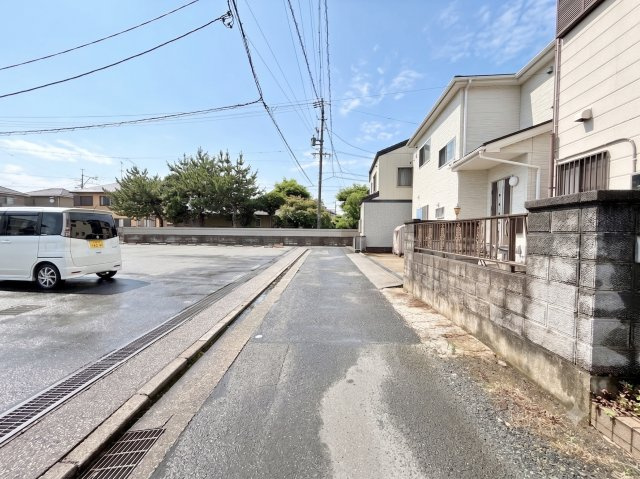 全面道路を西から東向きに撮影しました。正面が駐車場のため、開放的な空間が広がっています。