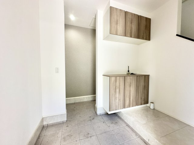 落ち着いた木目調の玄関収納が空間に温もりを与える、ゆとりある玄関ホール。上下セパレート収納で収納力も十分。家族全員の靴をすっきり収められ、来客時にもすっきりとした印象を保てます。