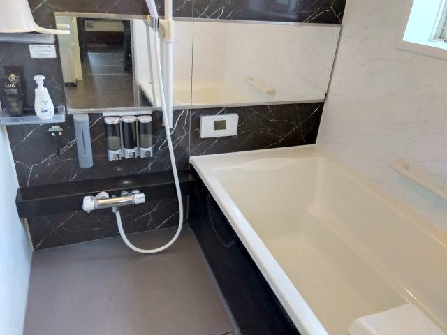 窓があるので明るい室内です。足を伸ばしてゆったりくつろげる広めの浴槽です。備え付けの台があるのでシャンプーを置いたり出来て便利です。