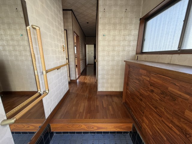 木目調のレトロで落ち着いた雰囲気が魅力的な玄関です。手すりが設置されており、ご家族皆さまが安心してスムーズに昇り降りできます。窓からの自然光も入り、大容量のシューズボックスも完備！
