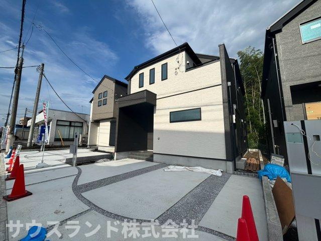 少し離れた位置から見た外観写真です。建物の立体感や窓の配置をご確認いただけます。手前には広い駐車スペースがあり、車を2台並べて停めても余裕がございます。青空に映える明るい住まいです！
