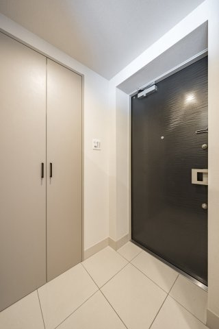 玄関は白地の大理石に重厚感のある玄関扉が映えるカラーセレクトを取り入れています。