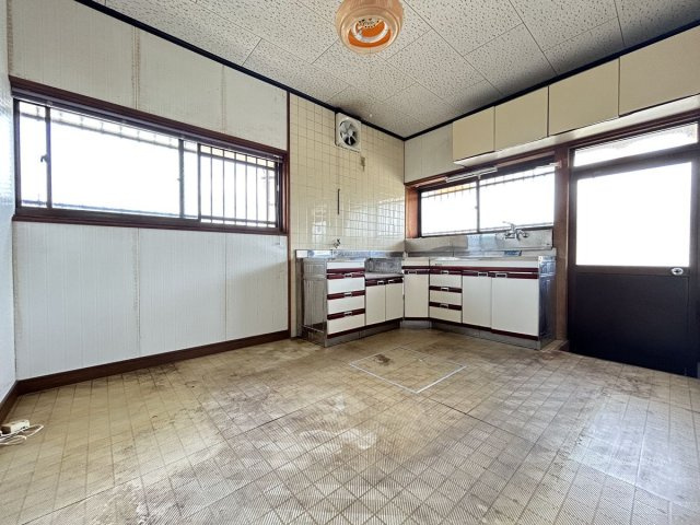 窓から差し込む光が明るい、勝手口付きのキッチン空間です。