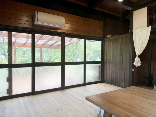 大きなガラス開口部から豊かな自然光と緑の景観を取り込み、開放感にあふれた心地よいひとときを過ごせるお部屋です。（視認性を高めるために備品類を削除する加工を行っております)