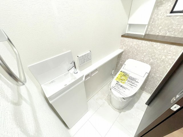 1階トイレ：タオル掛け、カウンターや洗面付きの便利なトイレ。人間センサーや温水洗浄便座機能もございます。