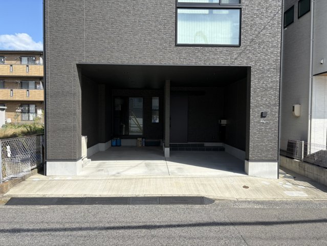 建物のデザインと一体感のあるインナーガレージ仕様。雨の日でも濡れずに玄関へ入れる便利な造りが魅力です。外壁と同系色でまとめられた落ち着きあるカラーが、全体の高級感を引き立てています。