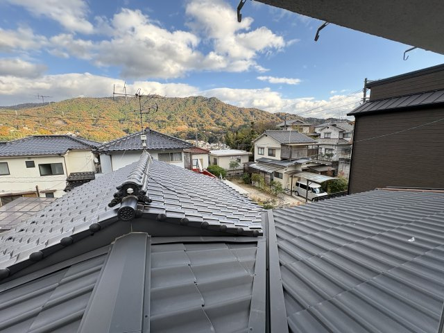 高台ならではの眺望が魅力の一枚。屋根越しに広がる山々の景色は四季折々の美しさを楽しめ、自然を身近に感じられるロケーションです。晴れの日は特に視界が開け、心地よい風とともに開放感を満喫できます。