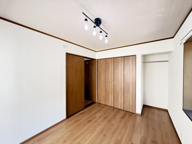 木目調の建具とフローリングが調和した、温かみのある洋室です。窓から自然光が入り、明るく開放感のある空間に。収納スペースも確保されており、お子様のお部屋や書斎としても活用しやすい広さです。