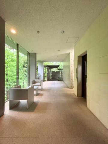 窓の先には、敷地内の豊かな植栽と美しい水景が広がるロビー。四季の移ろいを絵画のように切り取ります。
