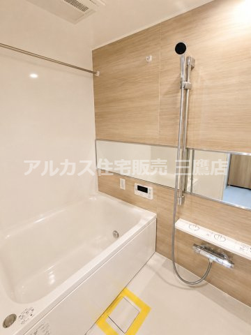 木目調のアクセントパネルが落ち着きを演出する、木質デザインの上質なバスルーム。