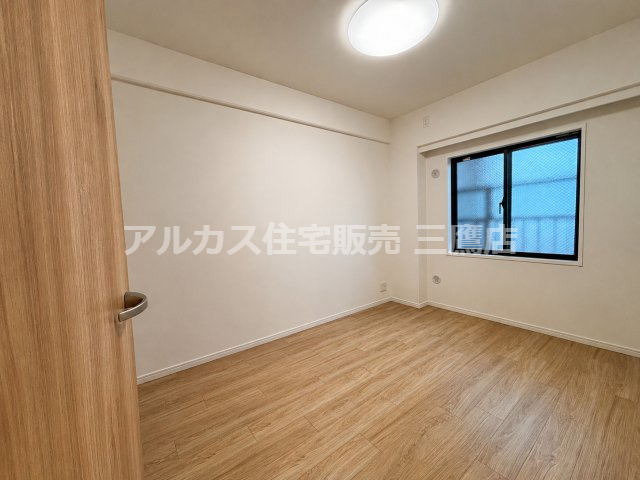 窓から自然光が差し込む、清潔感のある洋室。