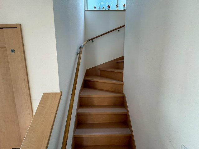 手すり付きで安心して昇り降りできる階段です。窓から自然光が入るため、昼間は明るく安全性にも配慮されています。日常動線として使いやすく、家族全員が安心して利用できる設計となっています。