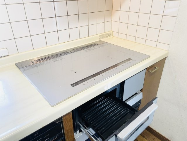 火を使わず調理できるIHクッキングヒーターを採用。天板がフラットでお手入れしやすく、グリルも備えた使い勝手の良いキッチン設備です。