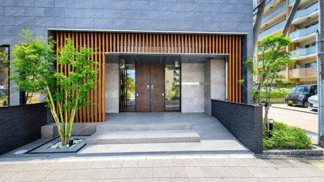 植栽が彩る美しいエントランス。重厚感あるデザインと落ち着いた雰囲気が、毎日の暮らしに安心感を与えてくれます。
