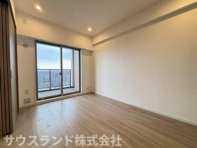 大きな窓から光を取り込む、明るく伸びやかな洋室。バルコニーへ直接出られるため、換気や洗濯物の取り込みもしやすい配置です。明るい木目の床が室内になじみ、家具も合わせやすい内装空間です。