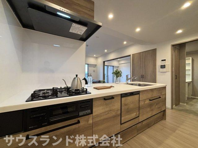 木目調の面材が印象的な対面キッチン。調理スペースを確保しながら、リビング側とのつながりも感じやすい配置です。収納や設備もまとまりよく、毎日の家事を進めやすい空間に仕上がっています。