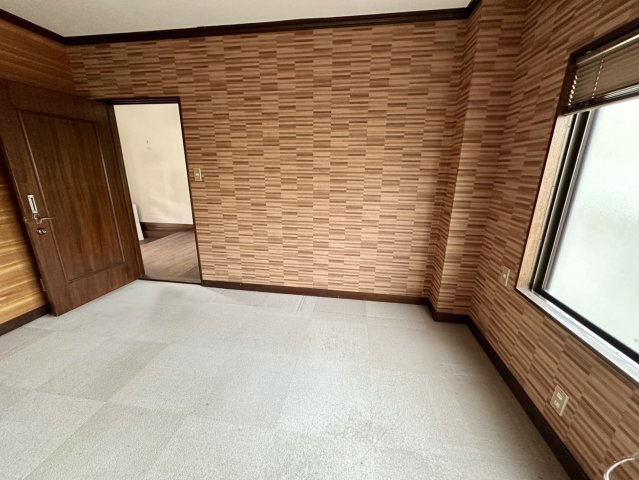 木目調のアクセントクロスが印象的な空間で、落ち着きと温かみを感じられる室内です。元クリニックの一室として利用されていたため、事務所や相談室など住居兼事業用物件ならではの魅力を備えた空間です。