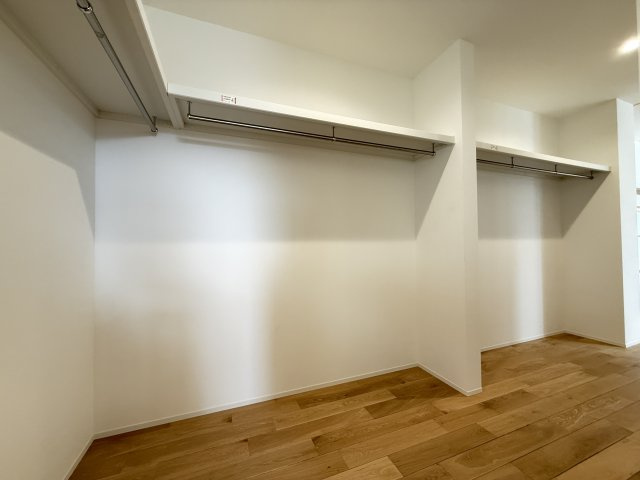 広々としたウォークインクローゼットは、衣類はもちろん季節物や大型の荷物までしっかり収納可能。ハンガーパイプが両側に設置されており、効率よく整理整頓できます。見渡しやすく出し入れもスムーズです。
