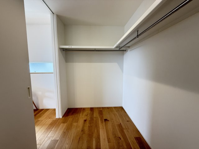 階段を上がってすぐ右に配置されたウォークインクローゼットは、動線の良さが魅力。帰宅後や朝の身支度時にもスムーズに出入りでき、日常使いに便利です。ハンガーパイプ付きで衣類をしっかり収納できます。