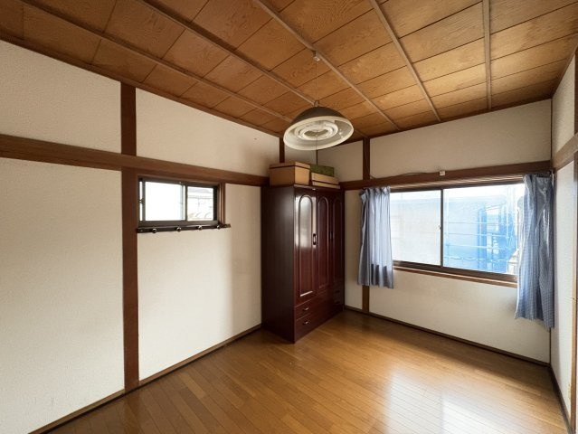 木の天井や柱が和の趣を残しながら、フローリングでモダンさも兼ね備えた落ち着きある洋室。2面採光で明るく、書斎や寝室にも最適。収納家具も配置されており、シンプルながら機能的な空間になっています。