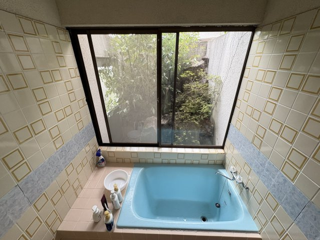 中庭を望む大きな窓が魅力の浴室。ブルーの浴槽とタイルがどこか懐かしく、自然を感じながら過ごすバスタイムが心身を癒してくれます。自然を眺めながらゆったりとしたバスタイムが楽しめます。