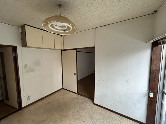 天井付近に収納棚を備えた洋室で季節物や普段使わない荷物の整理に便利な空間。居室部分をすっきり保ちやすく家具配置の自由度も高め。引き戸で隣室とつながるため用途に応じて寝室や書斎など柔軟な使い方ができます