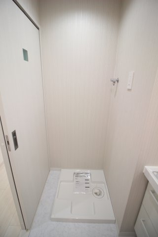 洗濯機置き場は洗面所の入り口横。壁内に収まるため行き来の邪魔になりません