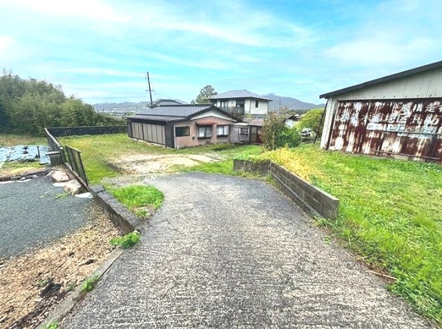 公道から敷地へ続く、緩やかな下り傾斜のアプローチ