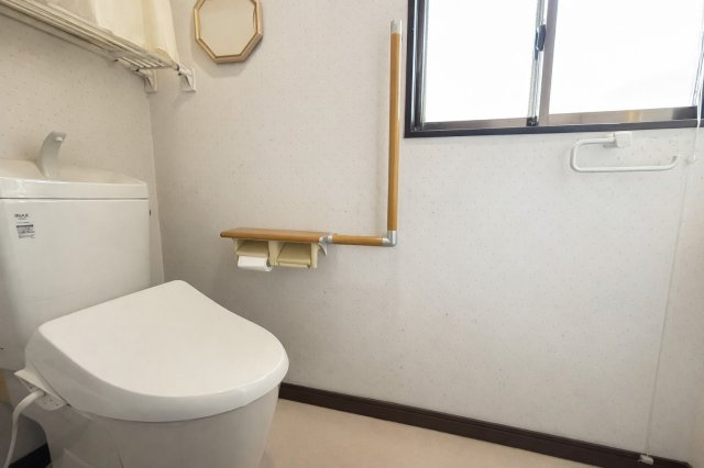 手すり付きで安心してお使いいただける2階トイレ。窓があり自然換気ができるため、明るく清潔感のある空間です。壁面にはカウンターやペーパーホルダーが設けられ、使い勝手にも配慮された設計となっております。