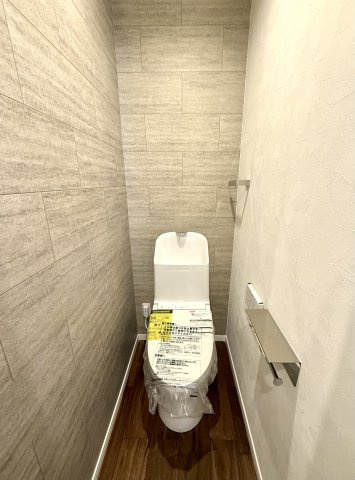石目タイル調のアクセントクロスがポイントのトイレです