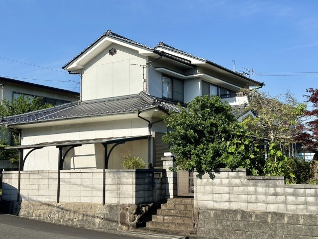 駅家町弥生ヶ丘。高台にある為、擁壁の上に建物が建っています。通風性に優れ、陽当たりも良好です。敷地は高さのある塀に囲まれ、門扉もあり、プライバシーや防犯面も安心です。門扉まで階段が数段あります。