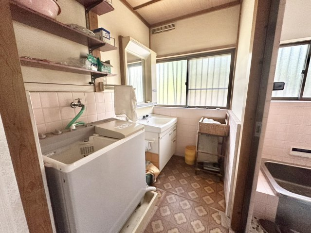 独立洗面台です。鏡、曇り止め機能、コンセントがついています。収納もあるのでこまごまとした用品を収納し、すっきりとした状態が維持できます。洗濯機置き場の上には可動式の棚が設置されています。