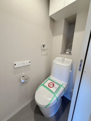 温水洗浄便座付きの清潔感あるトイレ空間。シンプルで落ち着いた内装に仕上げられており、毎日快適に使用できるよう機能性にも配慮されています。