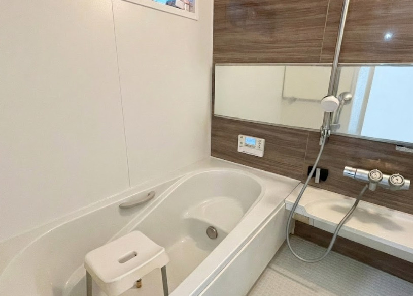 木目調パネルが温かみを演出する落ち着いた浴室。ゆったり浸かれる広めの浴槽で、一日の疲れをしっかりリセットできます。ワイドミラーと使いやすいカウンター付きで、家族の入浴にも便利な設計。
