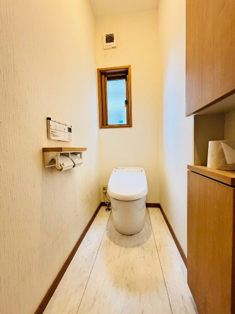 【トイレ/現地写真】採光窓もあり、換気もしやすいトイレ。上下にたっぷり入る収納付き。