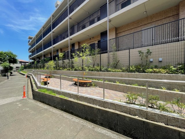 マンションの裏側の通路にはコモンガーデンがあり、ベンチも設置しております。