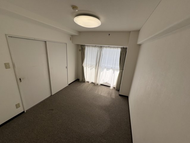 やわらかな色合いの壁と落ち着いた雰囲気が魅力の洋室。デスクや収納棚を置いても十分なスペースがあり、子供部屋や趣味の部屋など幅広く活用できます。仕切りカーテンを活用し、空間を柔軟に区切ることも可能です。