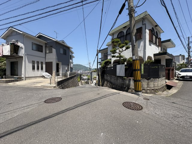角地ならではの開放感が魅力の立地で、陽当たり・通風ともに良好です。前面道路にはゆとりがあり、お車の出入りもしやすい環境。高台立地のため眺望も良く、周辺は落ち着いた住宅街が広がっています。