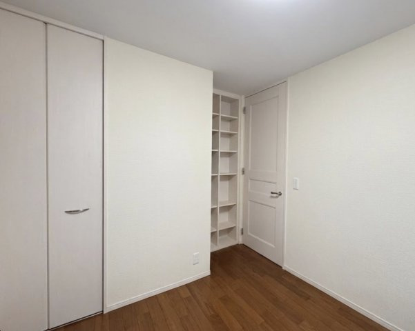 収納と可動棚が一体となった機能的な洋室。衣類だけでなく本や小物もすっきり整理でき、空間を有効活用できます。シンプルな内装で家具の配置もしやすく、子供部屋やワークスペースとしてもおすすめです。