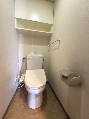 トイレ上部には、隠せる扉付き棚と出し入れしやすいオープン棚を完備。温水洗浄便座付きで、毎日快適にお使いいただけます。白を基調とした清潔感のある空間で、お手入れもスムーズです。