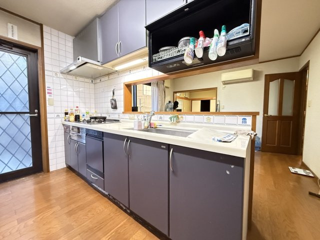 収納豊富なシステムキッチンは作業スペースも広く料理がしやすい設計。対面カウンター越しに家族の様子を見ながら調理できるのも魅力。勝手口付きでゴミ出しや買い物帰りの動線もスムーズな使い勝手の良いキッチン。