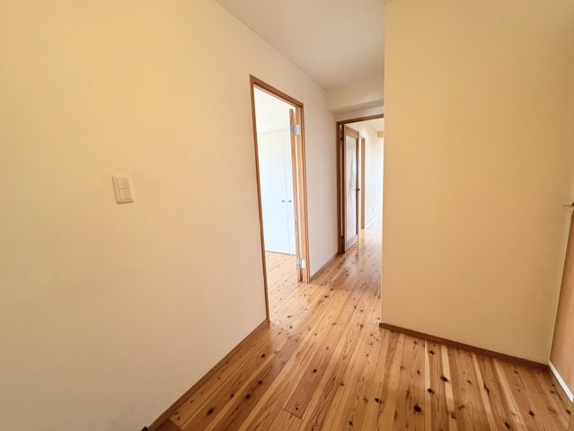 木目の美しいフローリングが住まい全体に温かみを与える廊下です。各居室へつながる動線がすっきりとまとめられており、日々の移動もスムーズ。白を基調とした壁と木製建具の組み合わせが落ち着いた印象です。