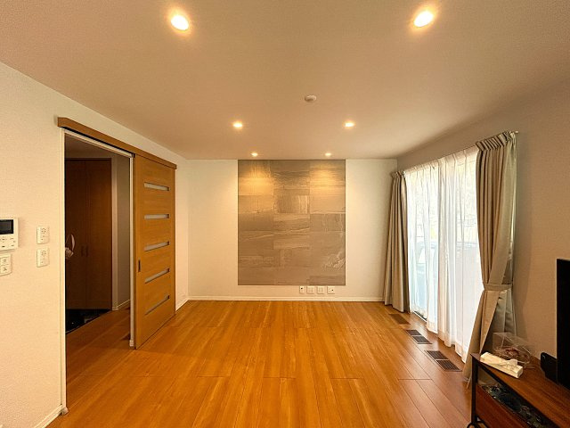 大きな掃き出し窓からたっぷりと自然光が差し込む明るいリビング。カーテン越しの柔らかな光が室内を包み込み、日中は照明が不要なほどの明るさです。広さにゆとりがあるためレイアウトの自由度も高いです。