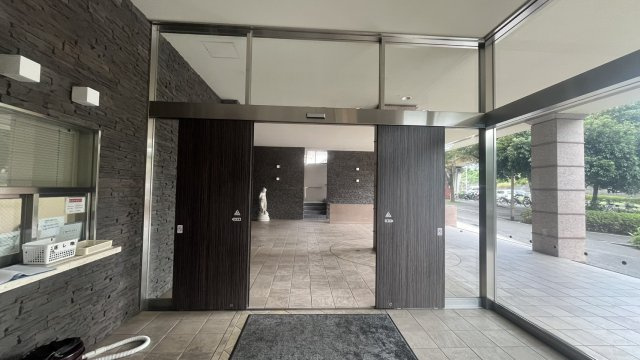 ガラス面を取り入れた明るく開放的なエントランス。自動ドアを採用しており荷物を持っている時にもスムーズに出入りできます。ダークカラーの壁面と建具が空間を引き締め落ち着きと高級感を感じる共用スペースです