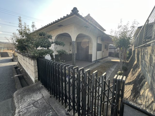 アーチ型のポーチが印象的な玄関まわり。前面は落ち着いた住宅街で、交通量も比較的少なく穏やかな住環境が広がります。門扉や塀が設けられており、プライバシーにも配慮された造りで防犯面にも安心感があります。