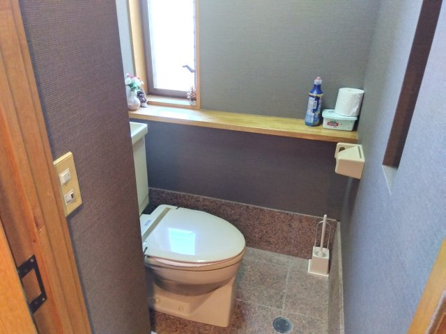 店舗部分のトイレです。ブラウンで落ち着いた清潔感ある空間でお客様にも安心してご利用いただけます。