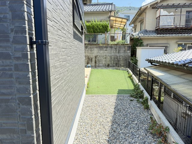 建物横には人工芝を敷いたスペースがありお子様の遊び場や家庭菜園ペットの遊び場としても活用できます。周囲はフェンスで囲まれているため安心感があり、プライバシーも確保。砂利敷き部分は雑草対策にもなります。