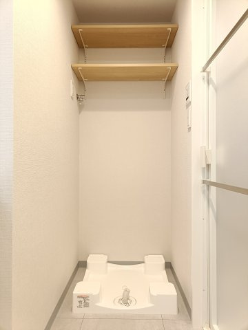 【室内洗濯機置き場】　棚板の高さを自由に動かせる可動棚を採用したニッチスペースに、ランドリーグッズやリネン類を収納しておけます。