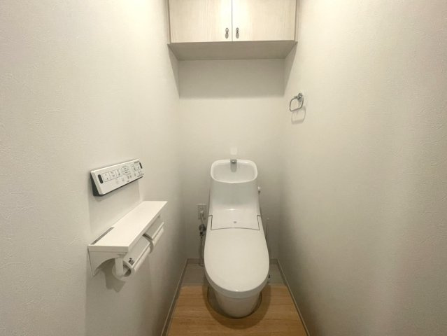 シンプルで清潔感あるトイレスペース。温水洗浄便座付きで快適性にも配慮されています。手洗いカウンターや上部収納も設けられており、使い勝手の良さと機能性を両立しています。毎日気持ちよく使用できる空間です。